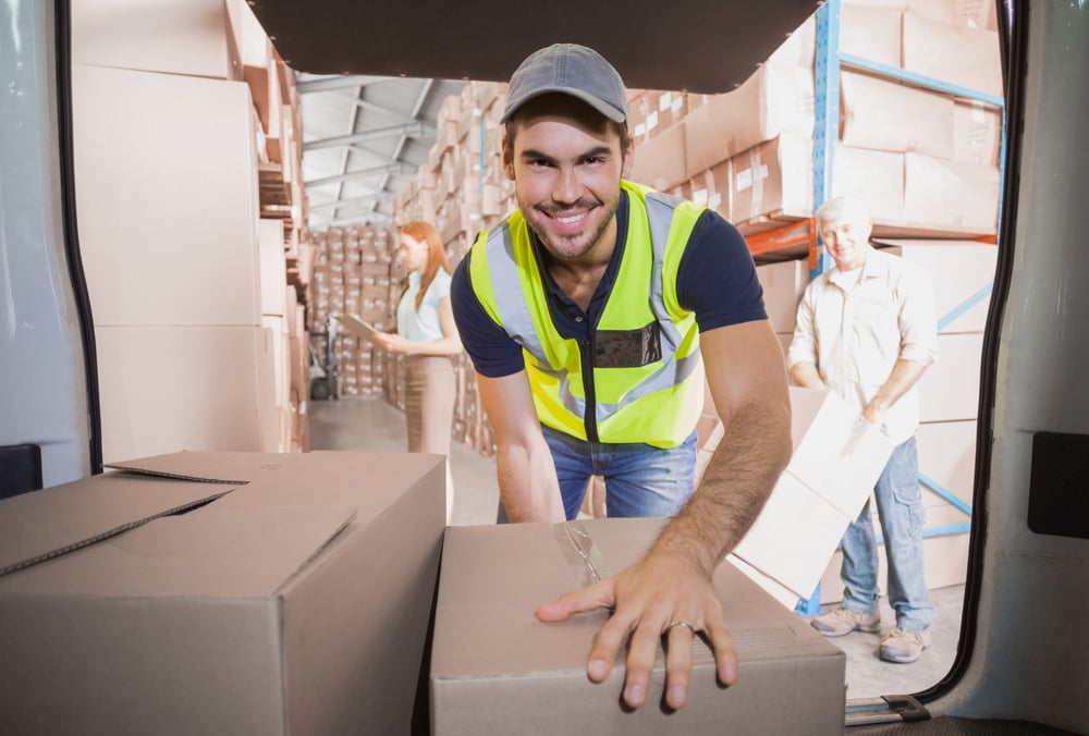 Delivery driver loading his van with boxes outside the warehouse