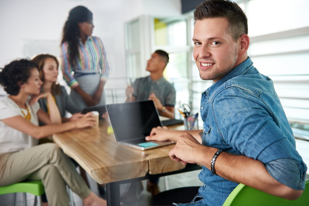 Image of a succesful casual business man using laptop during meeting